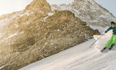 Skier on piste with rocks