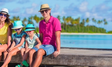 Family relaxing sitting near beach and sea on their summer holiday