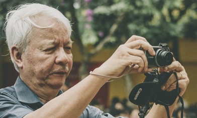 Elderly man holding camera taking a photo