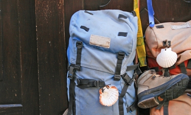 Two backpacks, one with boots attached, sat against a dark wooden door