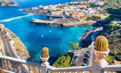 Elevated view of small coastal town in Canary Islands surrounded by blue waters