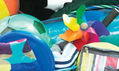 Beach balls, spades, a mat and cooler bag bundled together