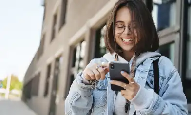 a student happily scrolling on their smartphone