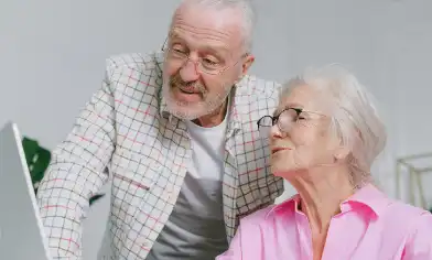 Elderly couple looking at something on a laptop screen