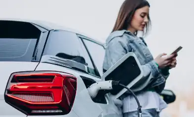 Woman charging her electric car with charging pistol
