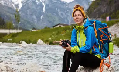 a person sitting on a rock in the mountains