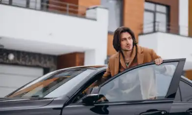 young handsome man sitting into car