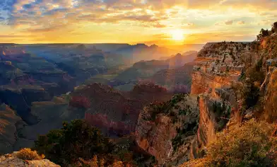 a bright sunrise over the cliffs of the Grand Canyon