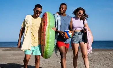 group of friends walking on the beach smiling and being happy