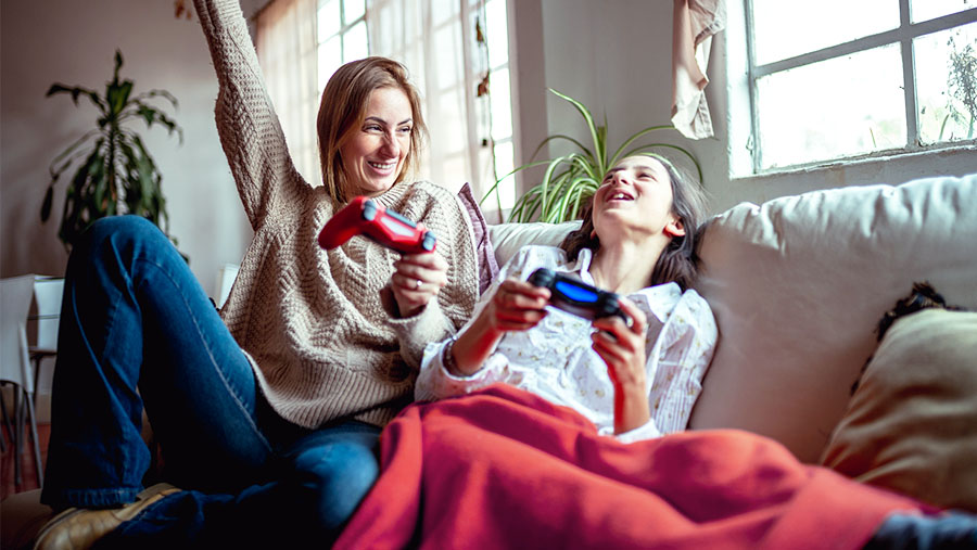 Two girls having fun playing console gaming with controller in their hands