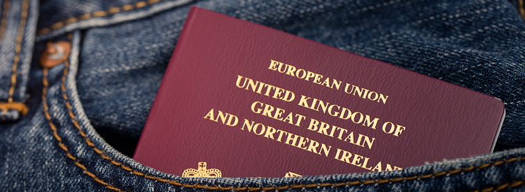 European Union passport partially sticking out of a front pocket of denim clothing