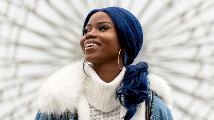 a person with blue hair and a white sweater