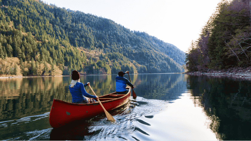 Two people canoeing along a mountain river in Canada