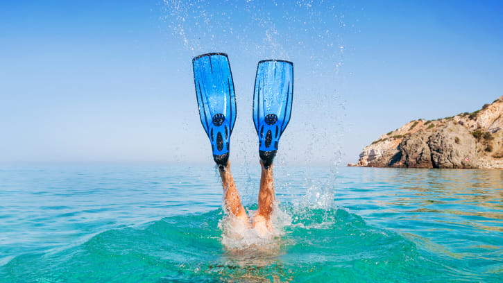 a person jumping in the water with flippers
