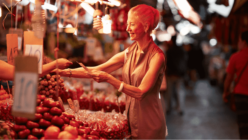 Woman at a street food market, paying for her goods