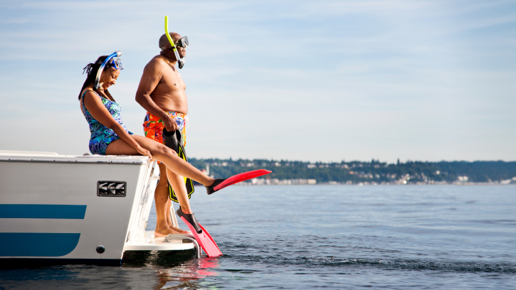 two people ready to dive into the water wearing snorkelling gear