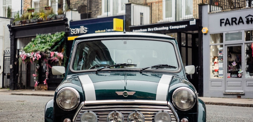 Vintage green mini car in front of High street shops
