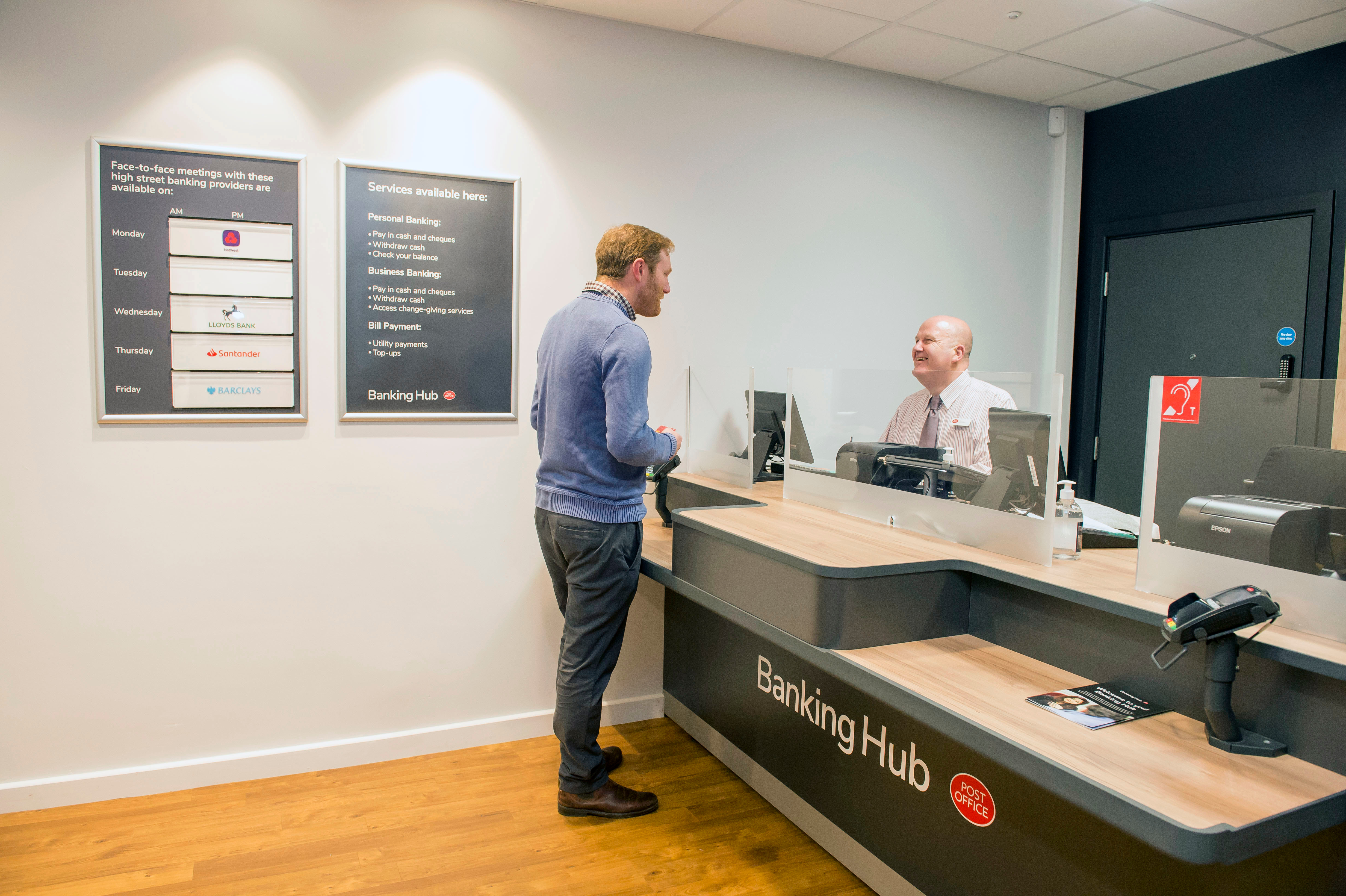 A customer being served at a Banking Hub counter