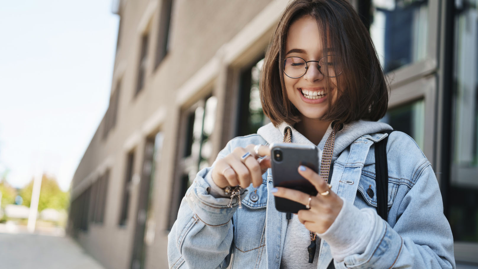 a student happily scrolling on their smartphone