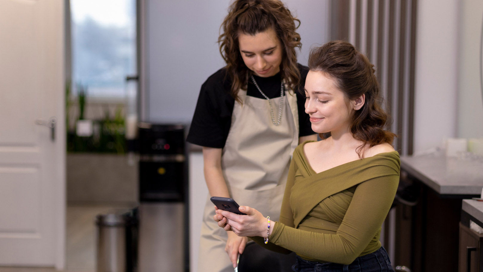 two women looking at a phone together