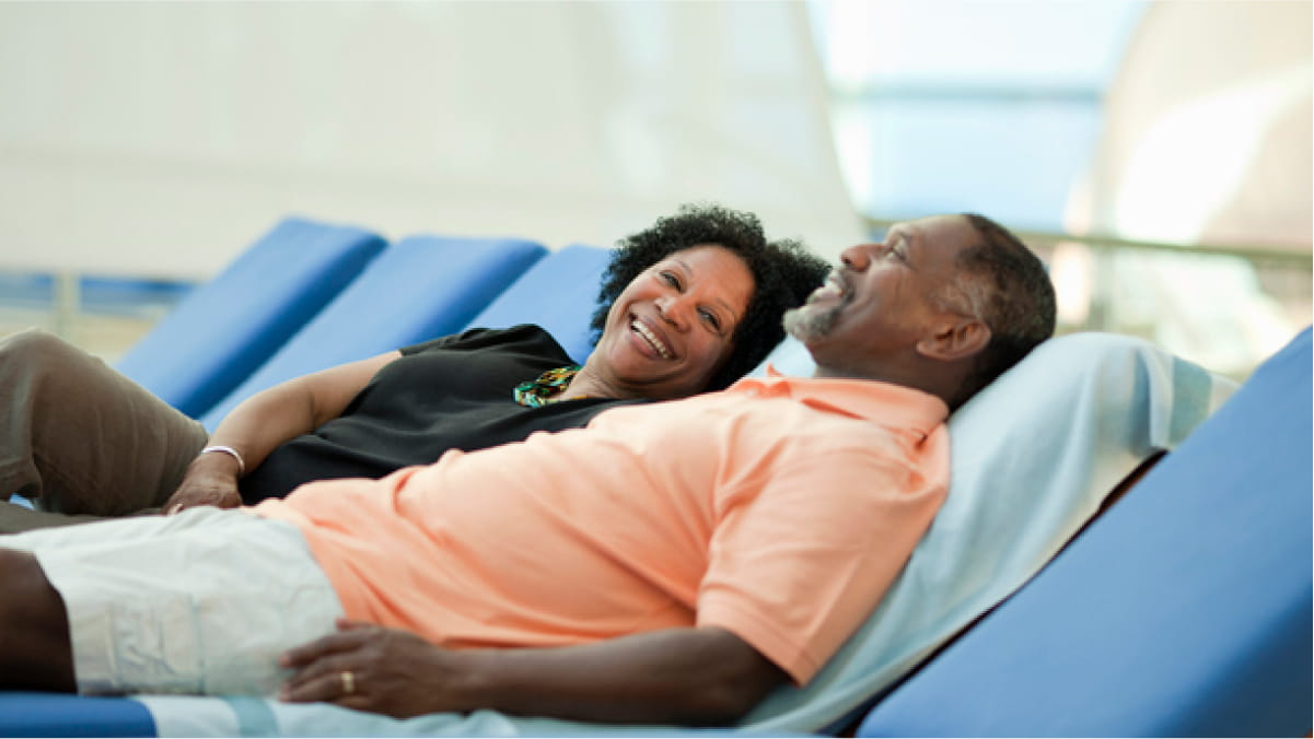 Couple laying down on a lounger relaxing