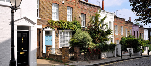 street view of houses with trees and street lamp