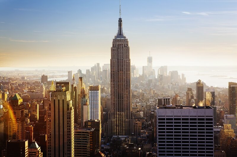 New York City with the Empire State Building at the center with surrounding buildings, sea and sky