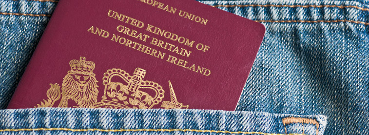 European Union passport partially sticking out of a back pocket of denim clothing