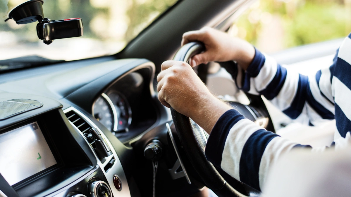 the dashboard and steering wheel of a car with a driver in position