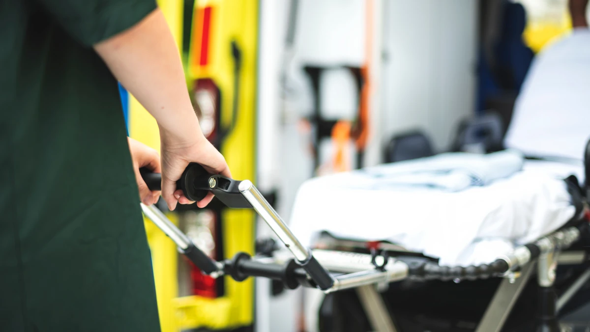 closeup image of a paramedic wheeling a gurney in a hospital