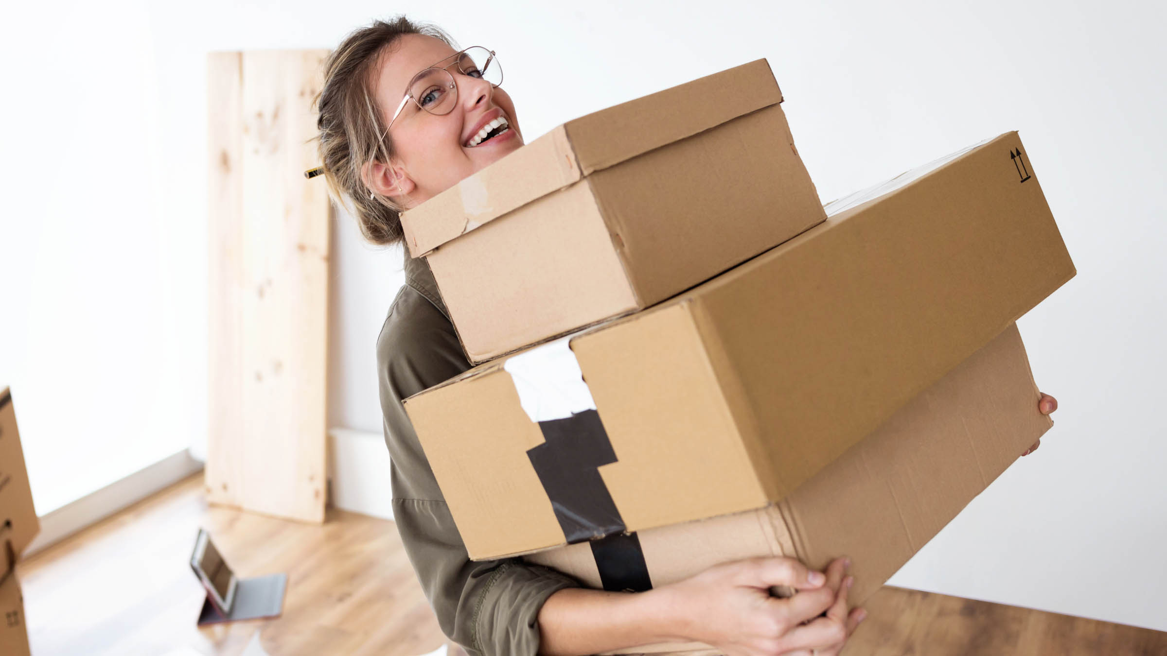 A person holding three brown boxes