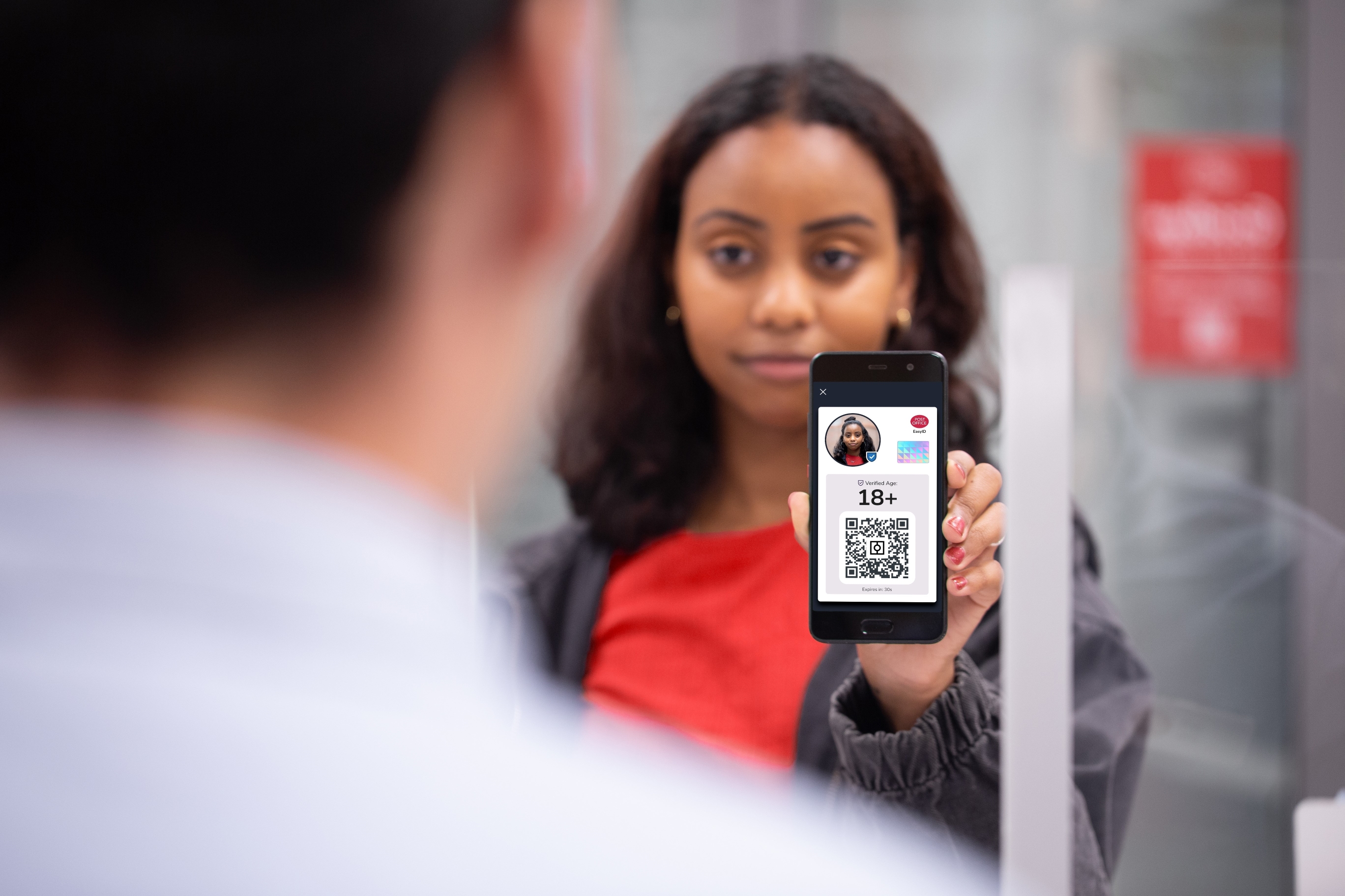 a person presenting their smartphone with a qr code and photo as identification
