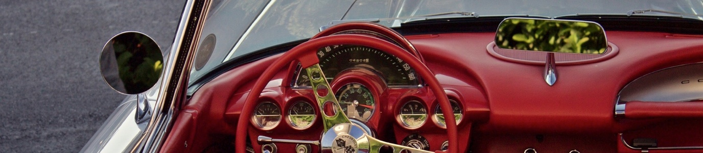 Vintage Chevrolet Corvette red dashboard with red steering wheel with chrome trims