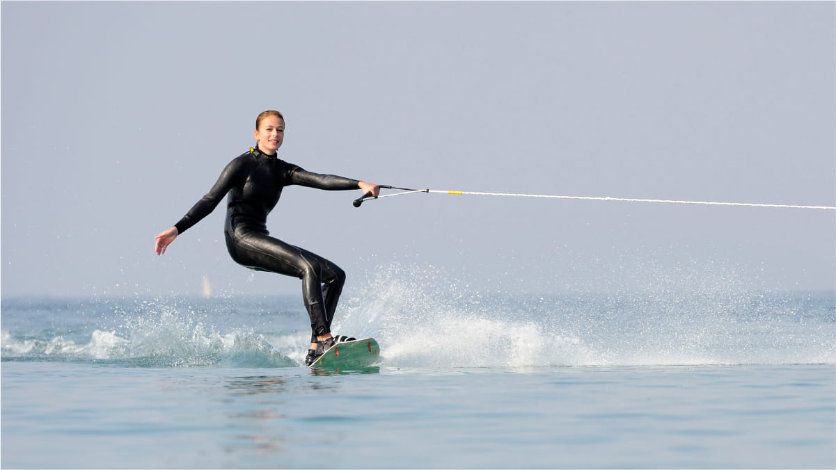 Female in a wet suit water skiing