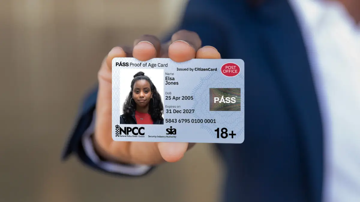 a hand holding up a post office 18 plus pass card