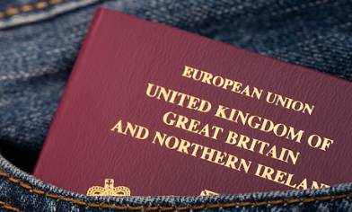 European Union passport partially sticking out of a front pocket of denim clothing