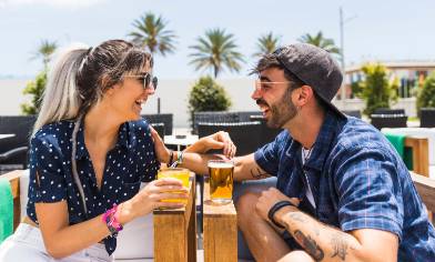 a happy couple having drinks at a beachside lounge