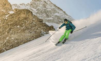 Skier on piste with rocks