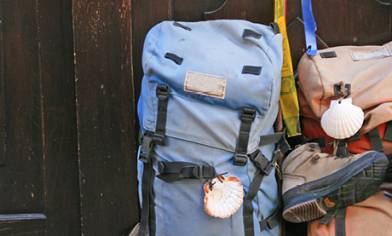Two backpacks, one with boots attached, sat against a dark wooden door