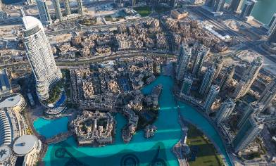 Aerial view of Dubai with Burj Khalifa, skyscrapers, and a turquoise lake
