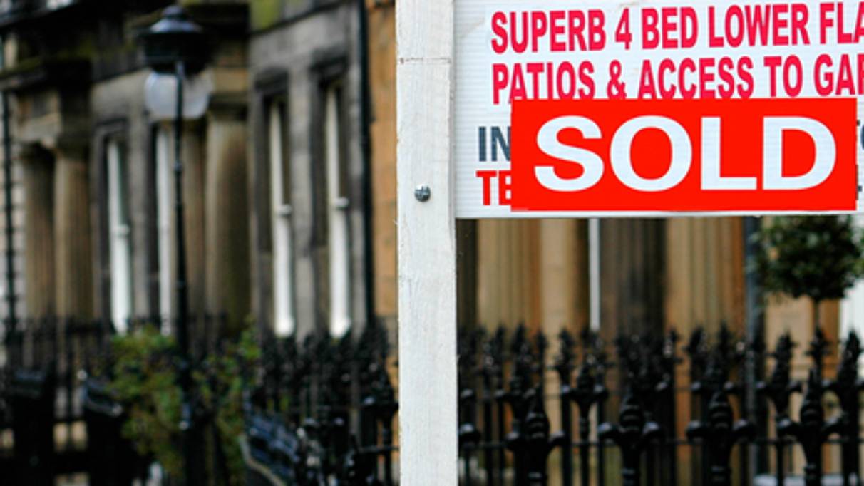 Sold Board in front of a house