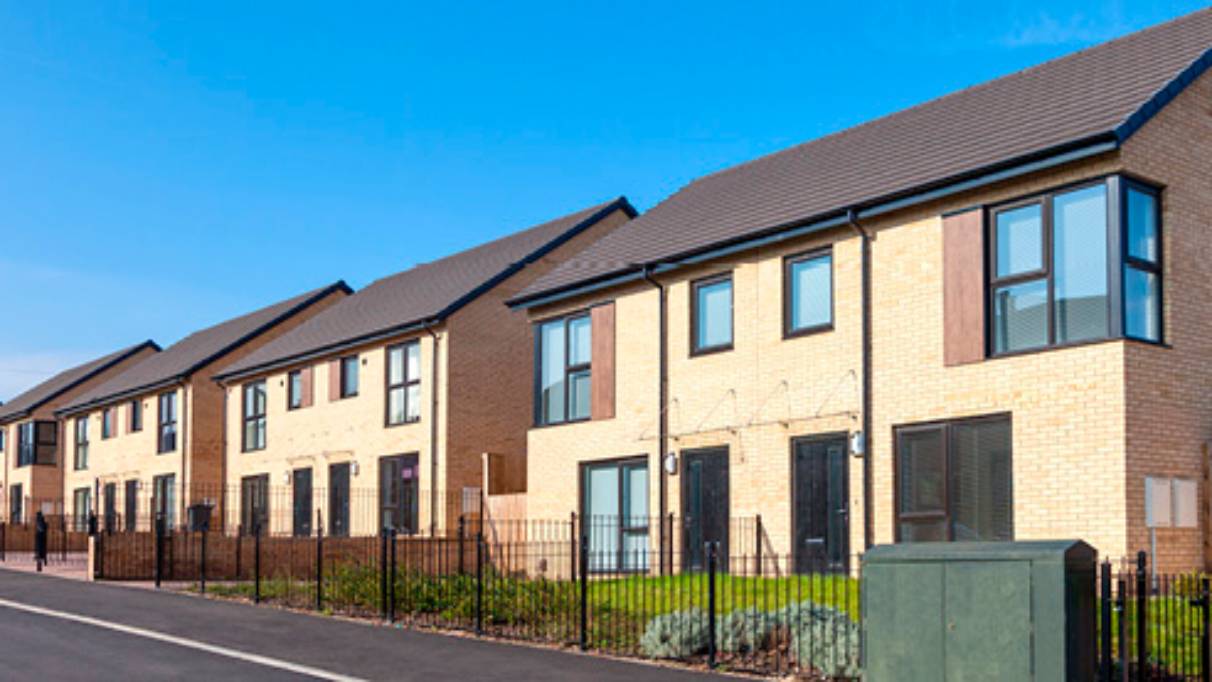 Row of houses on left side of a long road