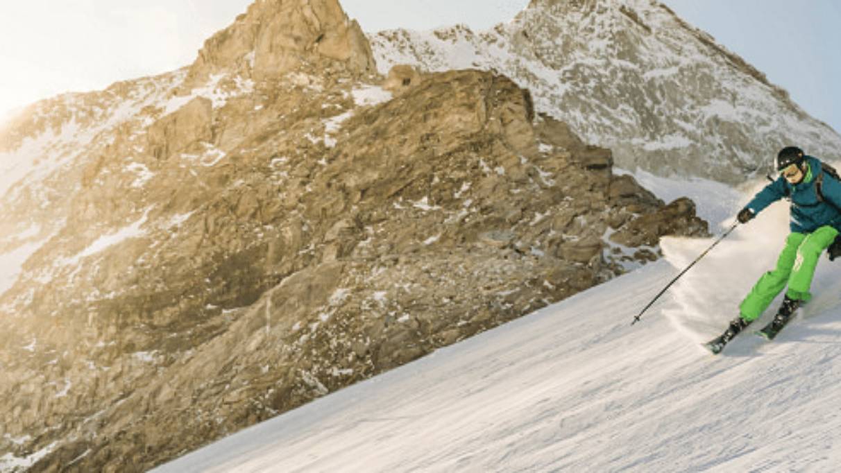 Skier on piste with rocks