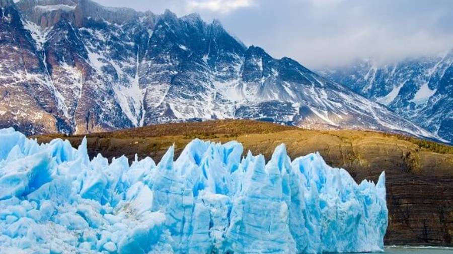Glacier in sea in front of Patagonian mountains