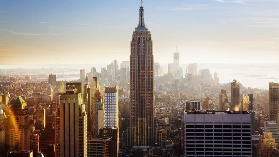 New York City with the Empire State Building at the center with surrounding buildings, sea and sky